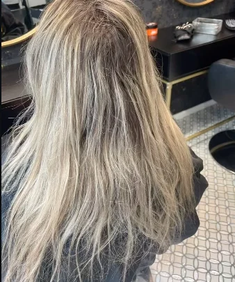 Mèches blondes devant les miroirs dorés du salon